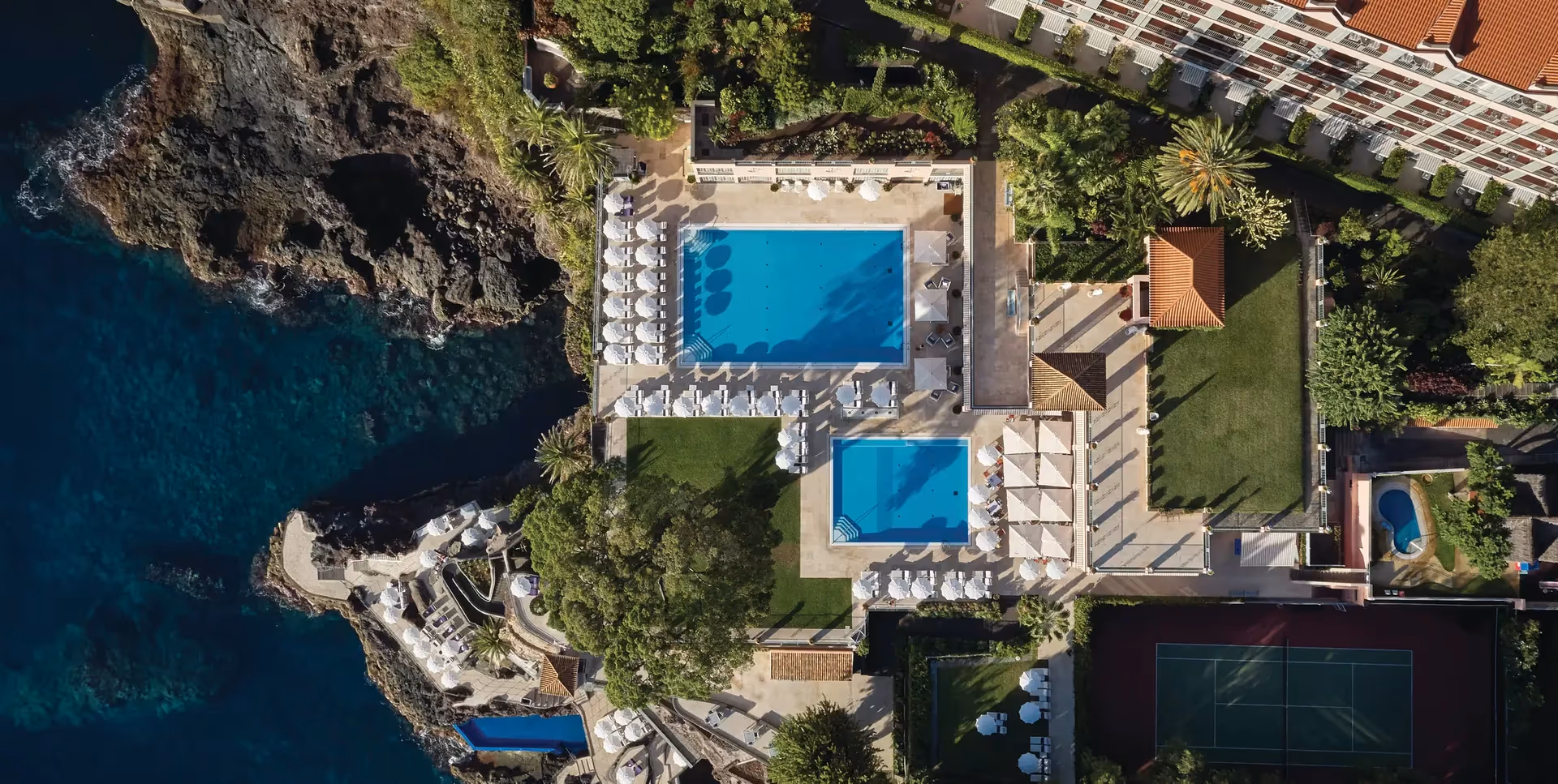 Resort pool terrace at dusk on Madeira's hotel coast