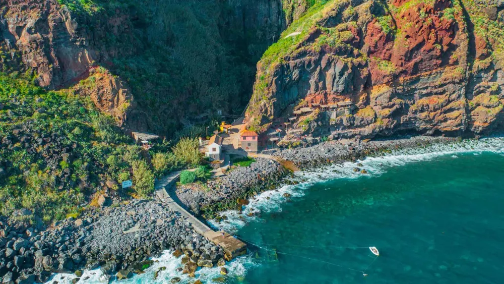 Pebble cove and restored fishermen's houses at Calhau da Lapa below Campanário, Madeira